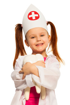 Smiling girl with pigtails dressed as a dentist hugging big tooth